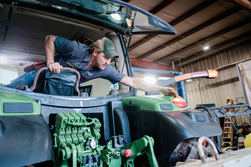 Field service technician working on a John Deere Tractor